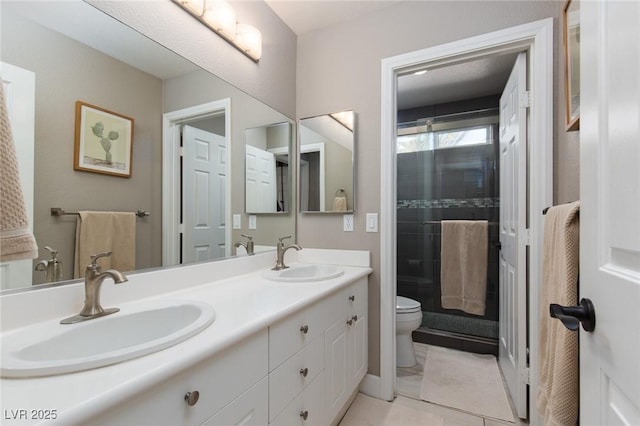 bathroom featuring tile patterned flooring, a sink, toilet, and double vanity