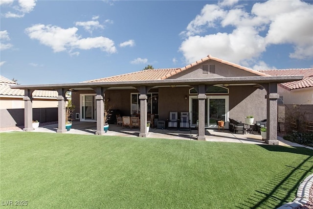 back of house with a yard, a patio, fence, and stucco siding