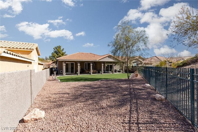 back of property with a tiled roof, fence, and stucco siding