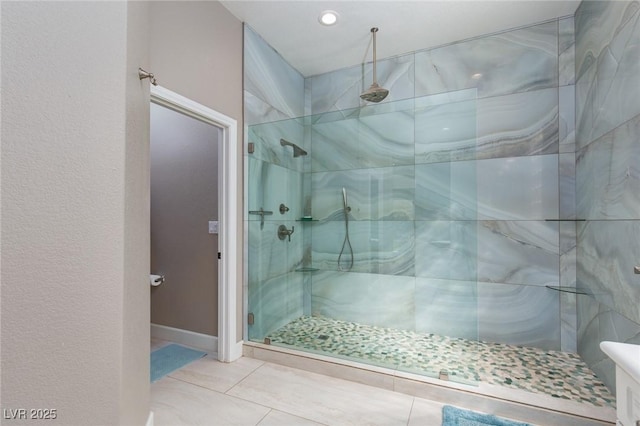 bathroom with a shower stall, baseboards, and tile patterned floors