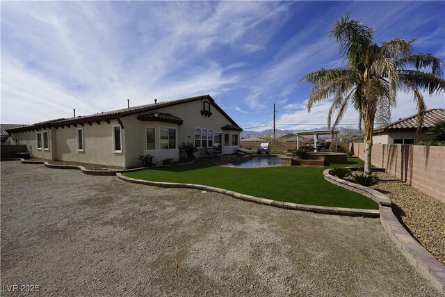 view of yard with an outdoor hot tub and a fenced backyard