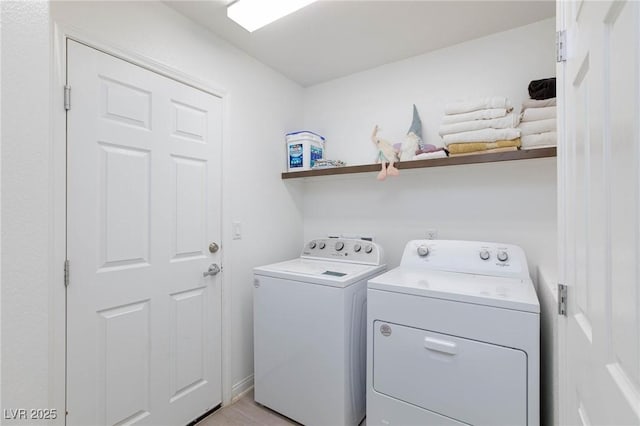 laundry area with laundry area, light wood finished floors, and washing machine and clothes dryer