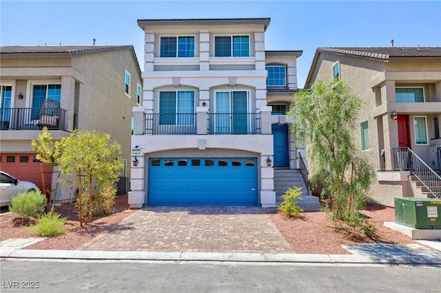 view of front of home with a garage, central air condition unit, decorative driveway, and stucco siding