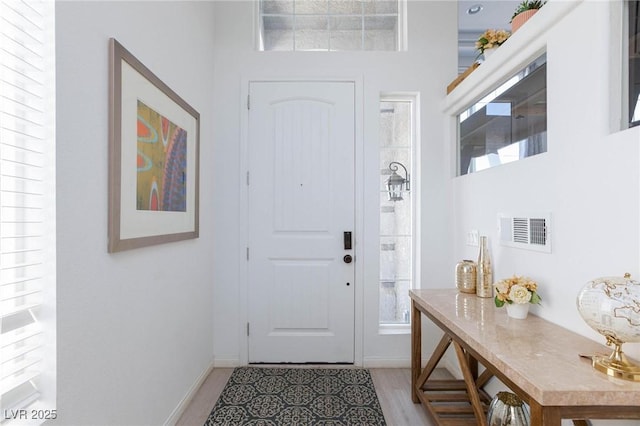 foyer entrance featuring visible vents and baseboards