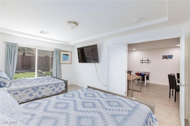 bedroom featuring light wood-type flooring, access to outside, visible vents, and baseboards