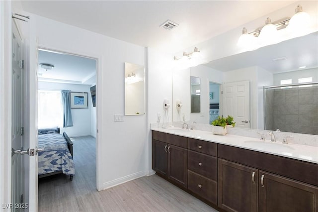 bathroom featuring plenty of natural light, visible vents, a sink, and ensuite bathroom