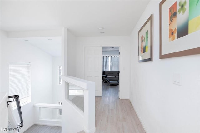 corridor featuring light wood-style floors and baseboards