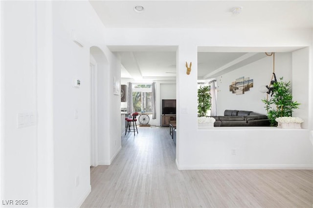 hall featuring light wood-style floors and baseboards