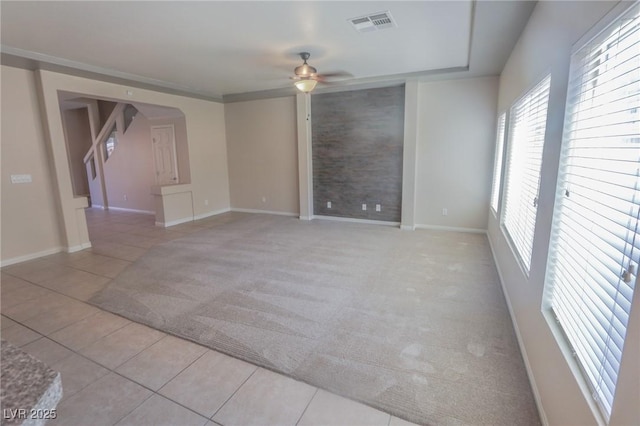 unfurnished room with a ceiling fan, light carpet, baseboards, and light tile patterned floors