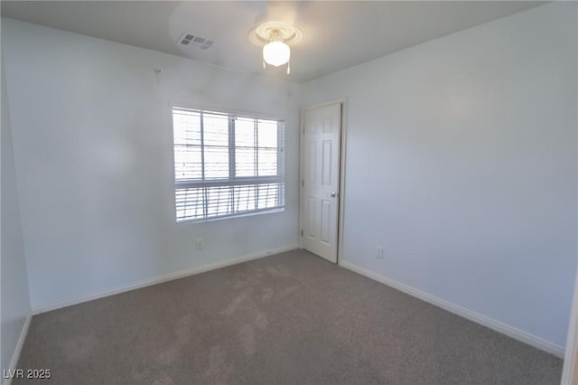 unfurnished room featuring carpet, visible vents, and baseboards