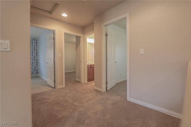 corridor featuring light carpet, recessed lighting, attic access, and baseboards