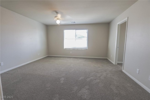 spare room with carpet floors, baseboards, and visible vents