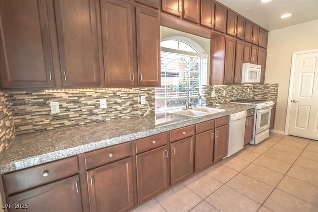 kitchen featuring light tile patterned floors, recessed lighting, white appliances, a sink, and tasteful backsplash