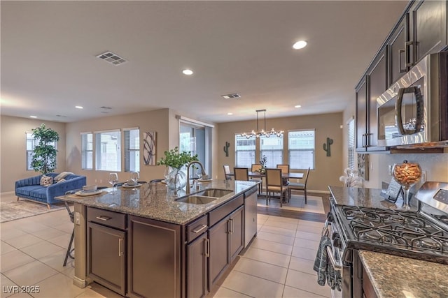 kitchen featuring appliances with stainless steel finishes, a sink, visible vents, and light tile patterned floors