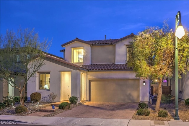 mediterranean / spanish home with stucco siding, decorative driveway, and a tiled roof