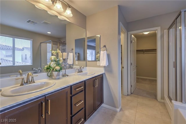full bath featuring double vanity, visible vents, a stall shower, and a sink