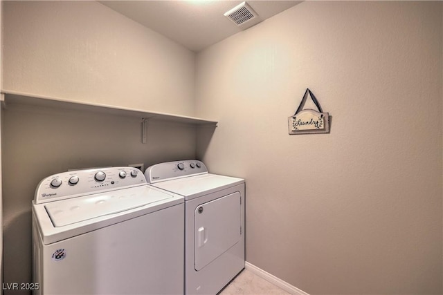 washroom with independent washer and dryer, visible vents, baseboards, and laundry area