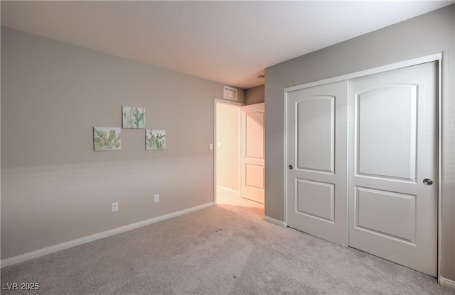 unfurnished bedroom with baseboards, a closet, visible vents, and carpet