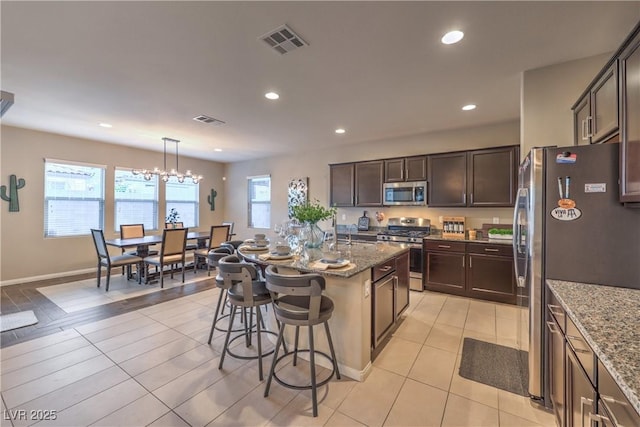 kitchen featuring stone counters, visible vents, and appliances with stainless steel finishes