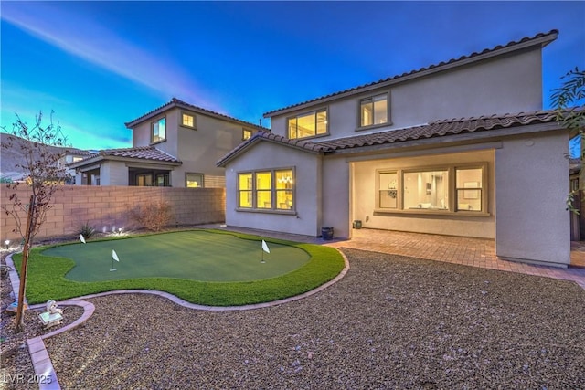 back of house with a patio area, a fenced backyard, a tile roof, and stucco siding