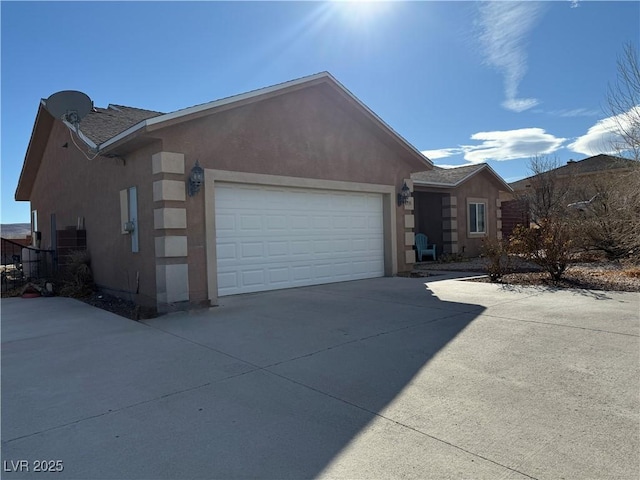 single story home featuring an attached garage, driveway, and stucco siding