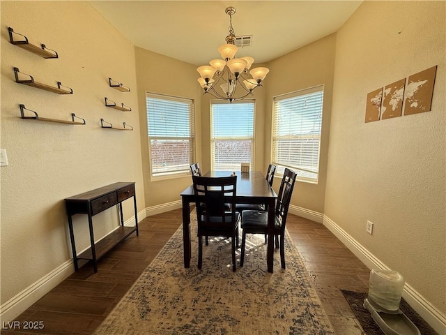 dining room with dark wood-type flooring, a chandelier, visible vents, and plenty of natural light