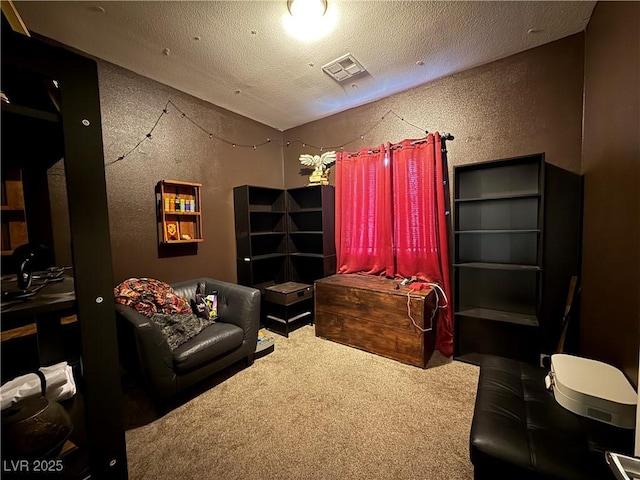 home theater room featuring carpet floors, visible vents, a textured wall, and a textured ceiling