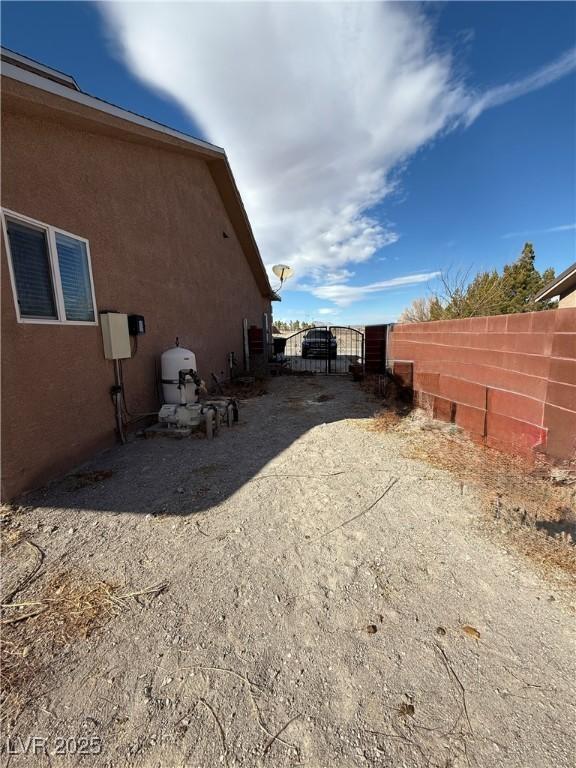 view of side of property featuring fence and stucco siding