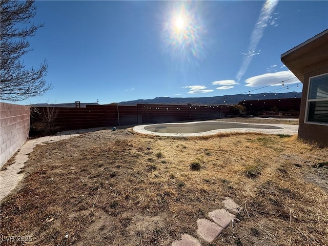 view of yard with a fenced in pool, a fenced backyard, and a mountain view