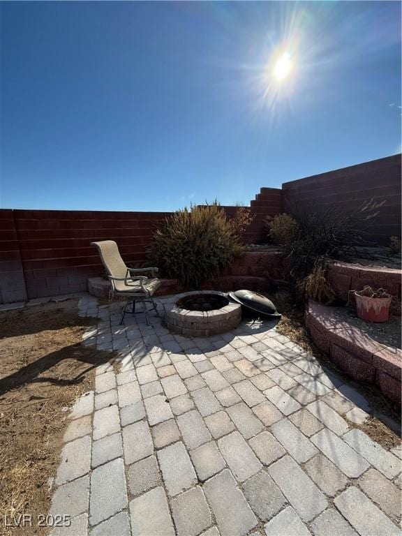 view of patio / terrace featuring an outdoor fire pit and fence