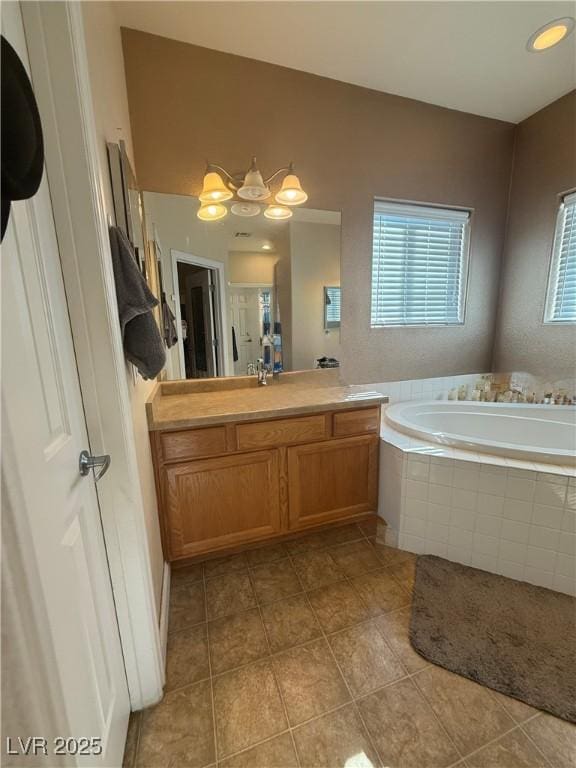 full bathroom featuring vanity, tile patterned flooring, and a bath