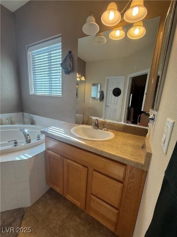 bathroom featuring tile patterned flooring, a garden tub, and vanity