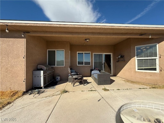 rear view of house with a patio and stucco siding