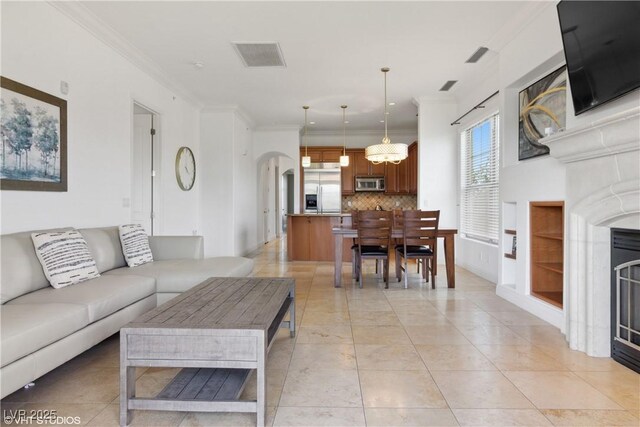21 Via Visione Unit 201, Henderson, NV 89011 - living area with crown molding, a chandelier, a fireplace, and arched walkways