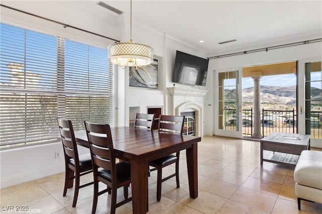 21 Via Visione Unit 201, Henderson, NV 89011 - dining area featuring tile patterned floors, a glass covered fireplace, crown molding, and baseboards