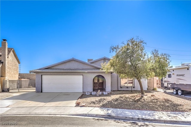 view of front facade with a garage, concrete driveway, and stucco siding