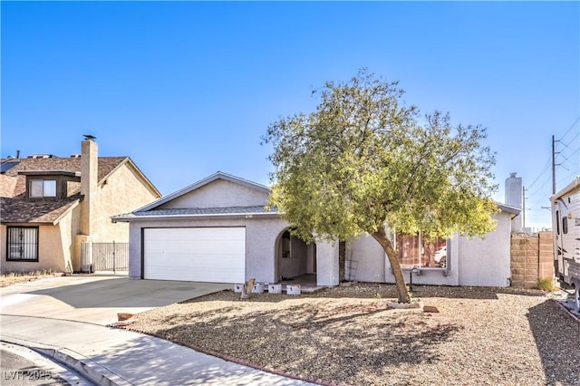 view of front facade featuring a garage, driveway, fence, and stucco siding