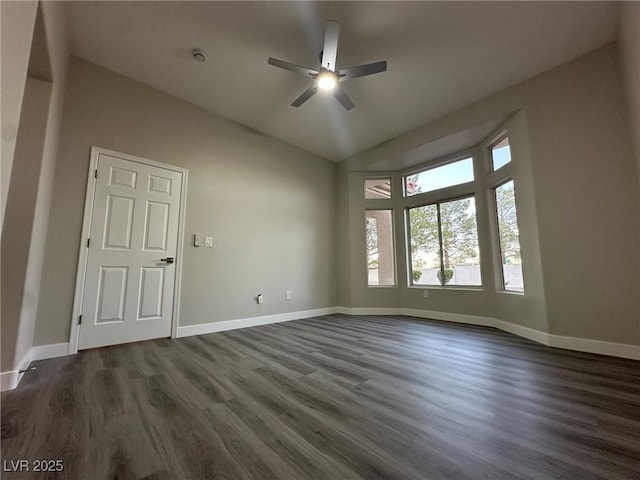 empty room featuring dark wood-style floors, ceiling fan, lofted ceiling, and baseboards