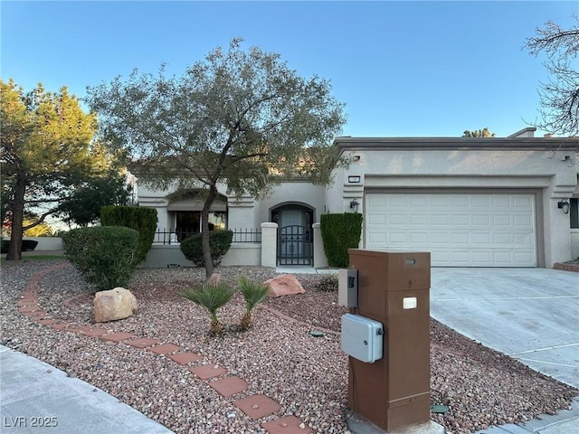 view of front facade with a fenced front yard, concrete driveway, an attached garage, and stucco siding