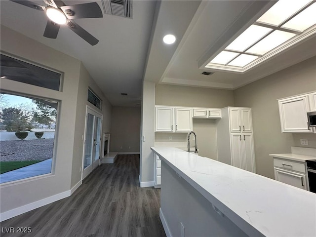 kitchen featuring dark wood-style floors, visible vents, baseboards, and white cabinetry