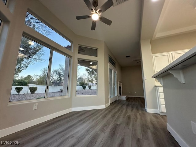 unfurnished sunroom featuring a ceiling fan, a healthy amount of sunlight, and visible vents