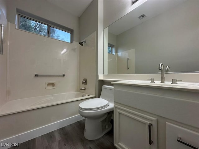 full bath featuring toilet, wood finished floors, vanity, visible vents, and shower / bathing tub combination