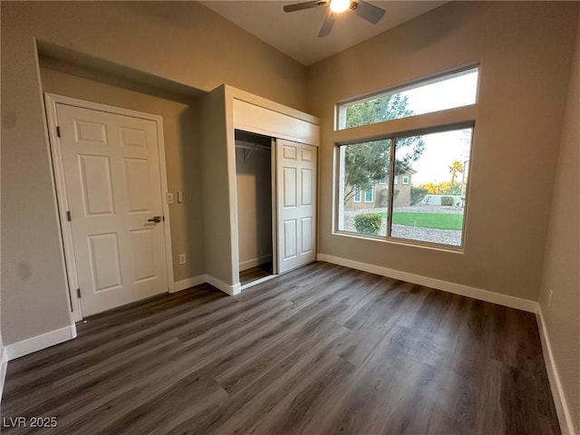 unfurnished bedroom featuring a ceiling fan, a closet, dark wood finished floors, and baseboards