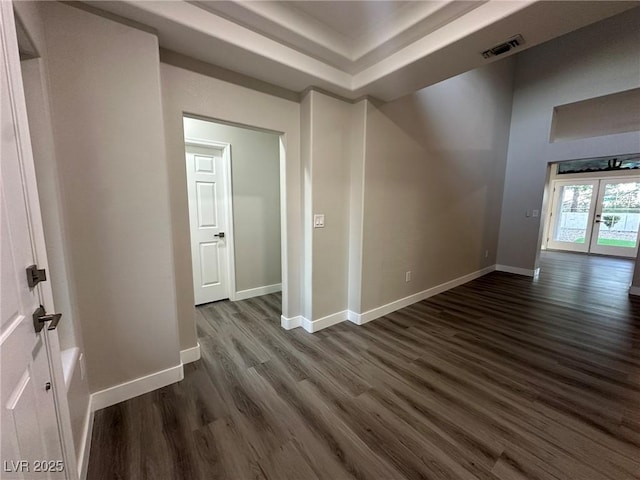 spare room with french doors, dark wood-type flooring, visible vents, and baseboards