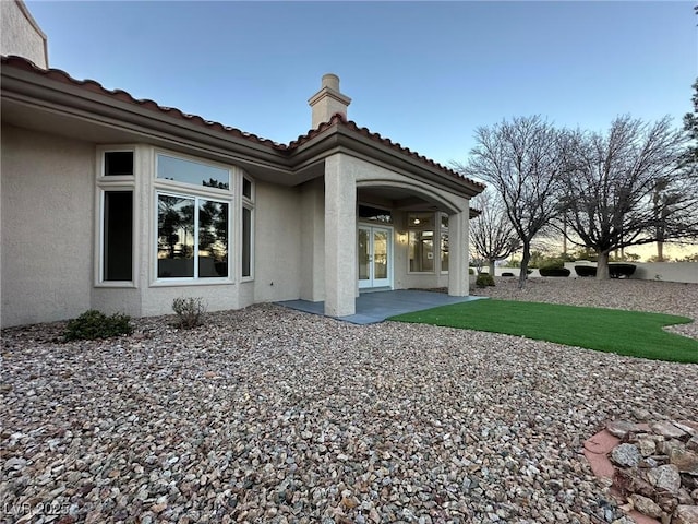 rear view of property featuring a patio and stucco siding