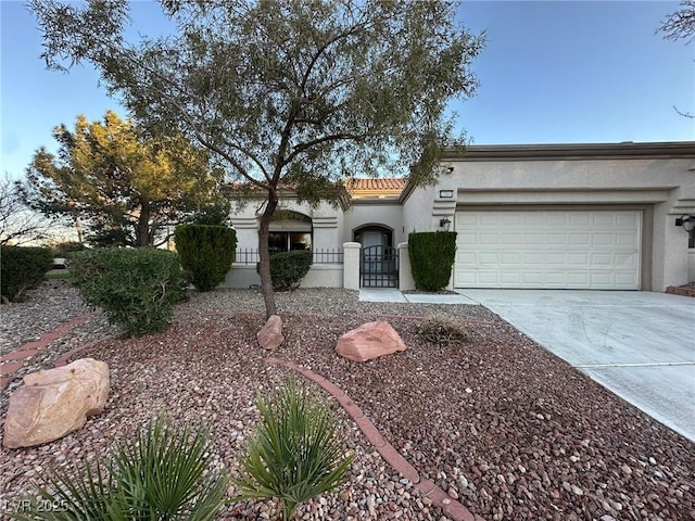 view of front facade featuring a garage, concrete driveway, a tiled roof, and stucco siding