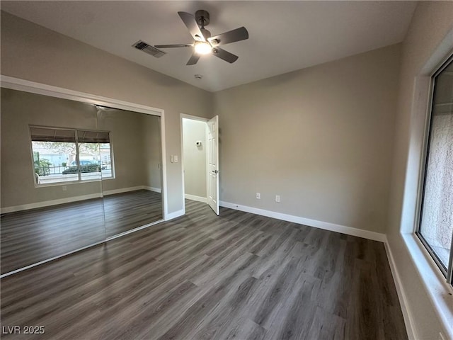 unfurnished bedroom with a closet, visible vents, ceiling fan, wood finished floors, and baseboards