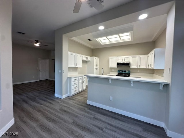 kitchen featuring light countertops, white cabinets, range with electric stovetop, and a peninsula