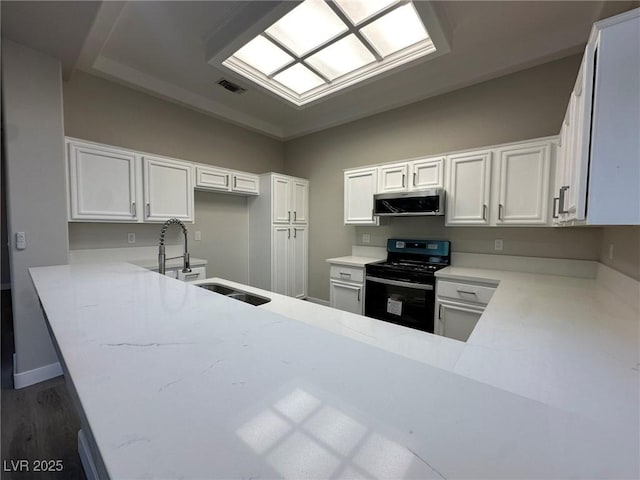 kitchen with black gas range, a sink, visible vents, white cabinets, and stainless steel microwave