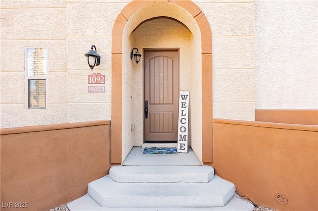 entrance to property with stucco siding